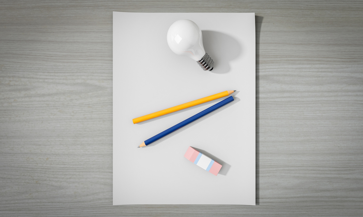 Top View of Pencils and Lightbulb on a Paper Sheet